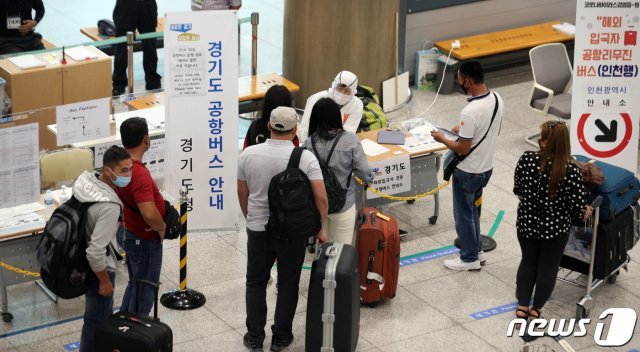 신종 코로나바이러스 감염증(코로나19) 해외 유입 사례가 늘어나는 가운데 14일 인천국제공항에서 해외입국자가 직원의 안내를 받고 있다. 이날 질병관리본부 중앙방역대책본부에 따르면 해외유입 감염자가 19명, 지역발생 감염자 14명을 기록했다. 2020.7.14/뉴스1 © News1