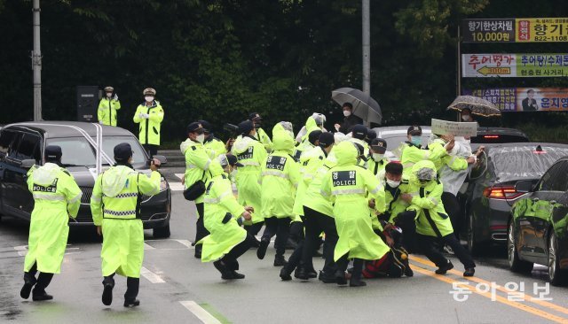 故 백선엽 장군의 운구차량이 진입하자 안장을 반대하는 단체 회원들이 진입 저지를 시도하다 경찰에 제지당하고 있다.