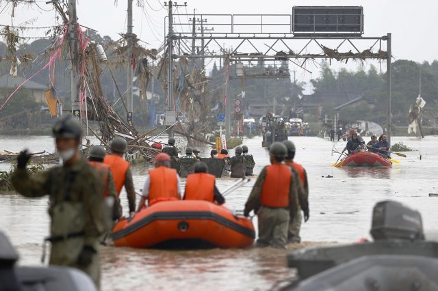 이달 초 일본 구마모토현에 내린 엄청난 폭우로 완전히 잠긴 도시에서 구조대원들이 수재민을 구조하는 모습. 이 지역에는 한 시간에 100mm가 넘는 폭우가 쏟아졌습니다. 뉴시스