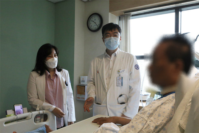 인하대병원에서 완치된 뒤 최근 고국으로 돌아간 중국인 A 씨(오른쪽)가 주치의 이정환 교수(가운데), 중환자실에서 돌봐준 박수현 교수(왼쪽)에게 치료 경과에 대해 설명을 듣고 있다. 인하대병원 제공