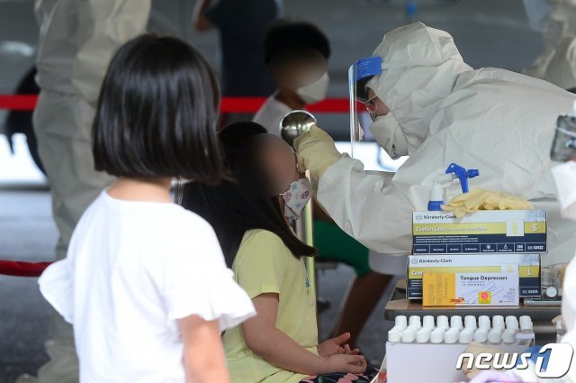 18일 오후 광주 서구 한 초등학교 이동선별진료소에서 이 학교 재학생들이 신종 코로나바이러스 감염증(코로나19) 검체를 채취하고 있다. 앞서 이날 오후 이 학교에 다니는 저학년·고학년 남매가 코로나19에 확진됐다. 2020.7.18 © News1