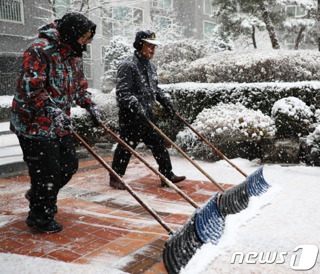 강원 춘천시 요선동의 한 아파트에서 경비원과 입주민이 단지 내에 쌓인 눈을 치우고 있다.2018.11.24/뉴스1 © News1