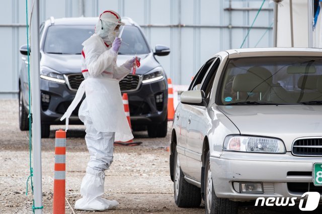 20일 신종 코로나바이러스 감염증(코로나19) 확진자가 이틀간 9명 발생한 서울 강서구 한 요양시설 인근 이대서울병원 드라이브스루 선별진료소에서 직원들이 차량에 탄 시민들의 코로나19 검체 체취를 하고 있다. /뉴스1 © News1
