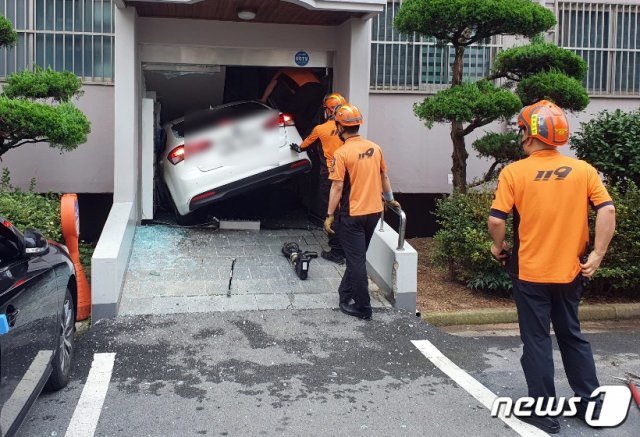 21일 오전 7시41분쯤 광주 북구 한 아파트에서 20대 남성이 몰던 승용차가 아파트 현관 출입문을 들이받은 사고가 발생, 출동한 119구급대원들이 운전자를 구조하고 있다.(광주북부소방서 제공) 2020.7.21 © News1