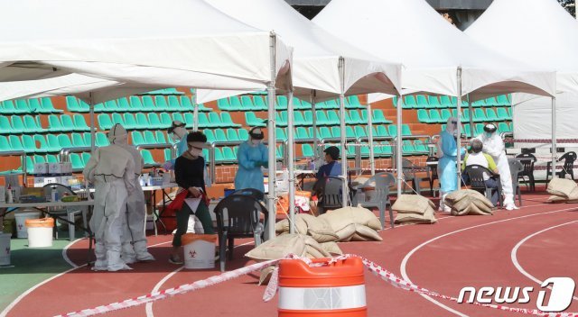 지역 내 감염이 이어진 지난 17일 오전 제주시 한림읍 한림체육관에 마련된 워킹스루 선별진료소에서 주민들이 검체 검사를 받고 있다. 2020.7.17/뉴스1 © News1