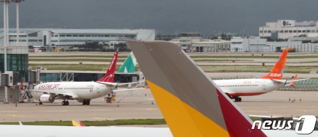 인천국제공항 계류장에 이스타항공과 제주항공 여객기가 멈춰서 있다. © News1DB