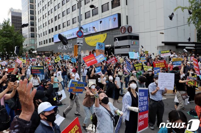 정부의 고강도 부동산 규제에 반발하는 시민들이 25일 저녁 서울 중구 예금보험공사 앞에서 열린 ‘부동산 규제정책 반대, 조세저항 촛불집회’에서 신발을 던지는 퍼포먼스를 하고 있다.2020.7.25/뉴스1 © News1