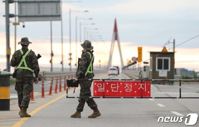 정부 당국이 북한이 신종코로나바이러스감염증(코로나19) 감염 통로로 지목한 재입북자로 최근 잠적한 20대 남성 탈북자를 특정하고 월북 경로 등을 조사중인 것으로 확인됐다. 26일 인천 강화군 북한 접경지 교동도로 진입하는 교동대교에서 군 병력들이 검문을 하고 있다. 2020.7.26 © News1