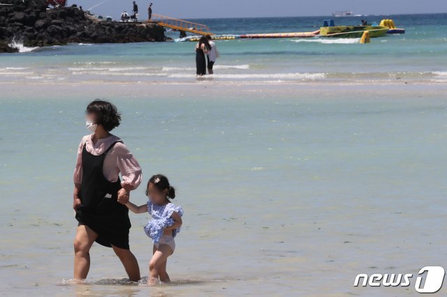 제주시 함덕해수욕장에서 마스크를 쓴 관광객들이 해수욕을 즐기고 있다. 2020.7.1 © News1