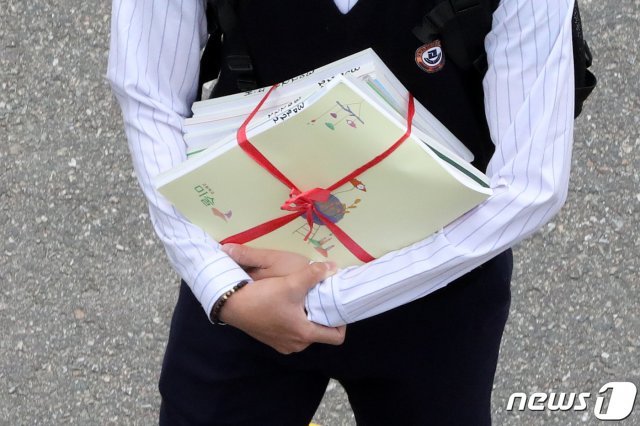 교과서를 들고 등교 중인 고3 학생. 2020.5.20 뉴스1