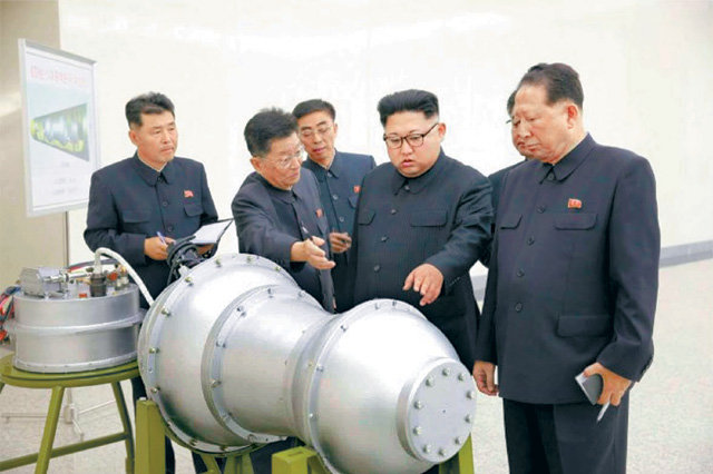 김정은 북한 국무위원장(당시 노동당 위원장·오른쪽에서 두 번째)이 2017년 9월 핵무기 병기화 사업지도 현장에서 대륙간탄도미사일(ICBM) 장착용으로 추정되는 수소탄에 대한 설명을 듣고 있다. 노동신문 뉴스1