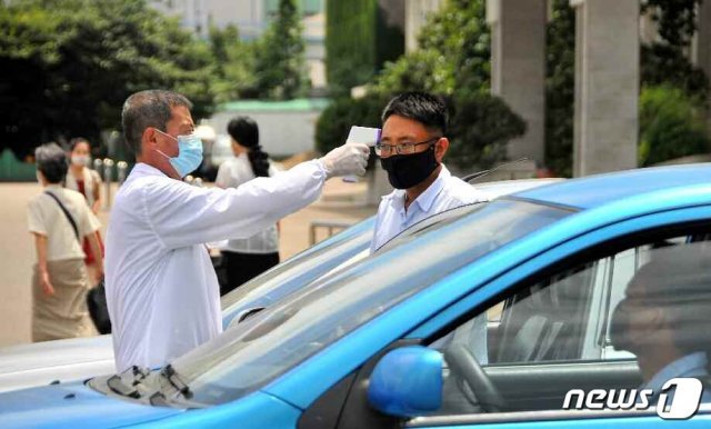 북한 노동당 기관지 노동신문은 5일 국내 신종 코로나바이러스 감염증(코로나19) 방역 현황을 조명했다. 사진은 평양시 중구역에서 주민의 체온을 재고 있는 방역 현장. (평양 노동신문=뉴스1)