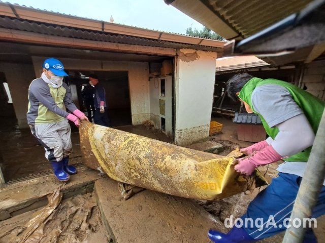 농협 안성교육원 직원들이 5일 안성시 죽산면에 위치한 집중호우 피해농가에서 복구 작업을 돕고 있다. 농협 제공