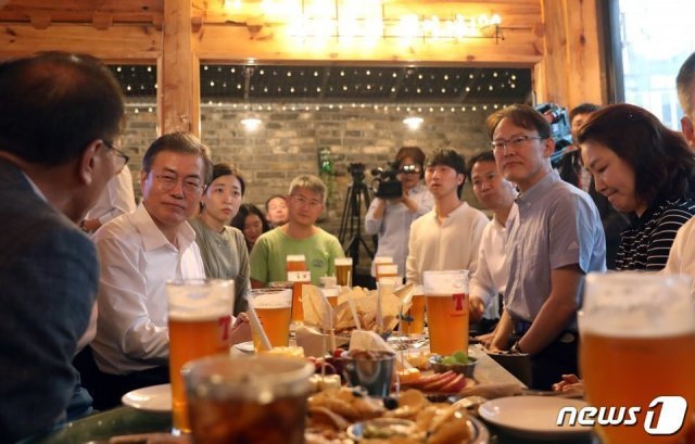 문재인 대통령이 26일 오후 서울 종로구의 한 호프집에서 퇴근길 직장인들을 만나 대화를 나누고 있다. 뉴스1