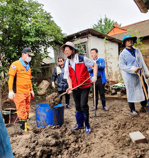 양승조 충남지사(앞줄 가운데)가 5일 충남 천안 목천읍 소사리 호우 피해 마을을 찾아 흘러내린 토사를 삽으로 퍼담고 있다. 충남도 제공
