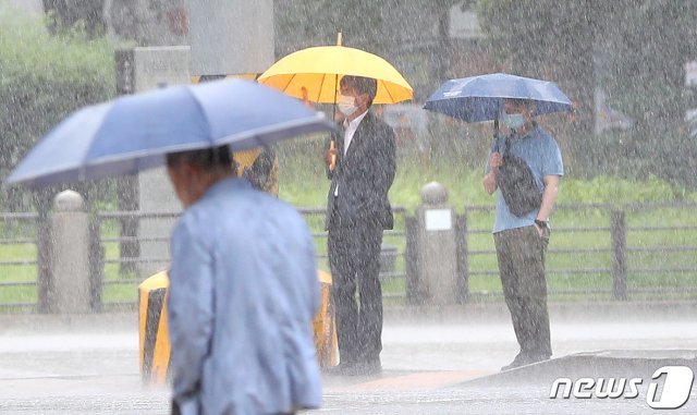 거리에서 우산 쓴 시민들이 신호대기를 하고 있다. 2020.7.29 © News1