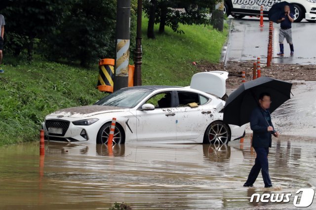 이달 초 발생한 폭우로 갑자기 불어난 물을 미쳐 피하지 못한 차량 모습. © News1DB