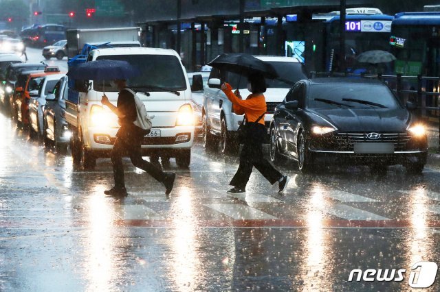 전국이 대체로 흐리고 대부분 지역에서 비가 내릴 것으로 예보된 10일 서울 종로구 광화문 네거리 일대에서 시민들이 장대비를 뚫고 힘겹게 걸음을 옮기고 있다.  2020.8.10/뉴스1 © News1