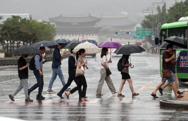 11일 오전 서울 광화문 네거리에서 출근길 시민들이 발걸음을 재촉하고 있다. 이날 기상청에 따르면 중부지역 장마는 지난 6월 24일 장마가 시작, 2013년의 49일과 함께 역대 가장 장마가 길었던 해로 기록됐다. 사진=뉴스1