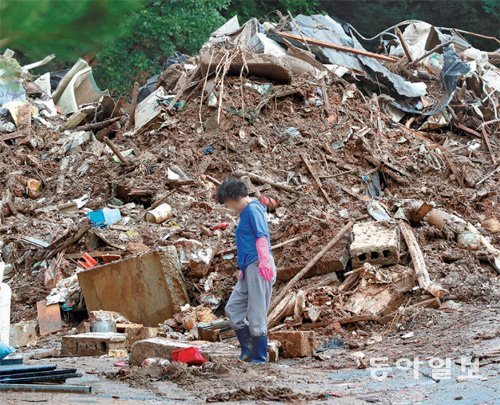 복구는 언제… 산사태와 침수 피해를 입은 경기 안성시 죽산면의 한 마을에서 11일 주민이 고개를 떨군 채 피해 복구 작업을 하고 있다. 안성=최혁중 기자 sajinman@donga.com