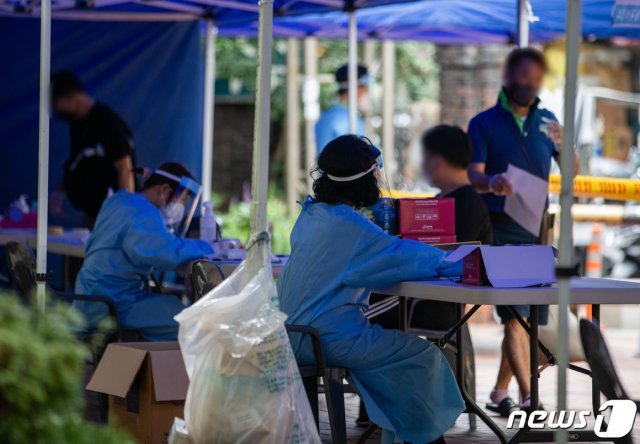 14일 서울 중구 통일상가 인근에 마련된 신종 코로나바이러스 감염증(코로나19) 임시 선별진료소에서 시민들이 검체검사를 받기 위해 대기하고 있다./뉴스1 © News1