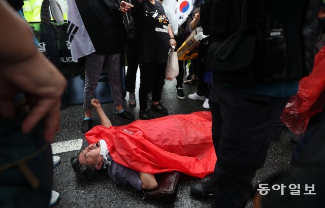 75회 광복절인 15일 시민들이 서울 광화문 일대에서 열린 ‘8·15 광화문 국민대회’에 참여해 정부와 여당을 규탄하고 있다. 한 집회 참가자가 도로에 누워 구호를 외치고 있다.