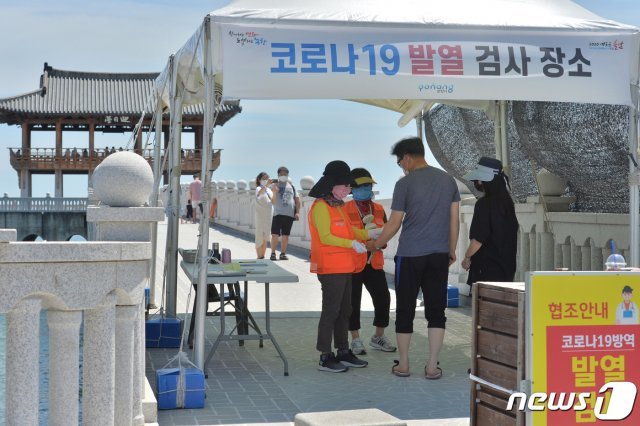 신종코로나바이러스 감염증(코로나19)가 전국으로 확산될 기미를 보이는 가운데 16일 오후 경북 포항시 북구 영일대해수욕장 해상 전망대인 영일대 입구에서 보건소 직원들이 입장객들의 체온을 확인하고 있다. 2020.8.16/뉴스1 © News1