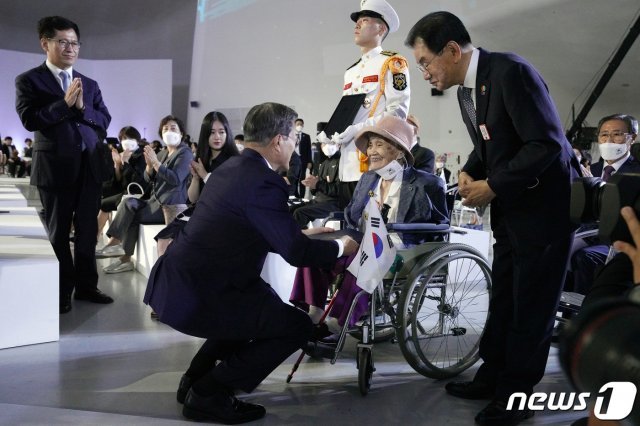 문재인 대통령이 15일 서울 동대문디자인플라자(DDP)에서 열린 제75주년 광복절 경축식에서 독립유공자 고 최사진씨의 배우자 박명순씨에게 대통령 표창을 수여하고 있다. (청와대 제공) 2020.8.15/뉴스1