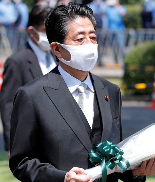 아베
 신조 일본 총리가 15일 제2차 세계대전 전몰자 중 신원을 알 수 없는 ‘무명전사’와 민간인 유골이 안치된 봉안당 겸 묘지공원인
 도쿄 ‘지도리가후치’에 헌화할 꽃다발을 들고 있다. 최근 건강 이상설이 제기되고 있는 아베 총리는 17일 도쿄 게이오대병원을 
찾아 건강검진을 받았다. 6월 정기 건강검진을 받은 지 두 달 만이다. 도쿄=AP 뉴시스