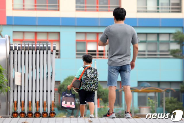수도권에 신종 코로나바이러스 감염증(코로나19) 확산세가 이어지는 가운데 18일 오전 경기도 수원시내 한 초등학교에서 한 학부모가 등교하는 자녀를 바라보고 있다. 2020.8.18 © News1