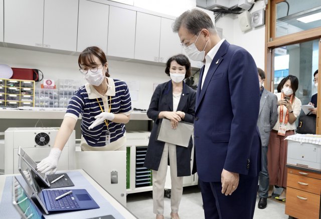 문재인 대통령이 18일 오전 ‘한국판 뉴딜, 현장에 가다’의 일환으로 그린 스마트 교육을 시행 중인 서울 중구 창덕여자중학교를 방문해 테크매니저로부터 스마트 교육에 활용하는 태블릿PC에 대한 설명을 듣고 있다. 사진=청와대 제공