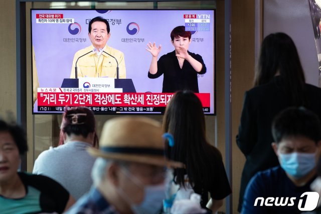 18일 서울역에서 시민들이 신종 코로나바이러스 감염증(코로나19) 사태와 관련한 정세균 국무총리의 대국민담화를 지켜보고 있다. 정 총리는 지난 16일 서울과 경기지역을 대상으로 실시한 사회적 거리두기 2단계 격상을 보다 강화하기 위해 해당 지역에 인천을 추가하기로 했다고 대국민담화를 통해 밝혔다. 2020.8.18/뉴스1 © News1