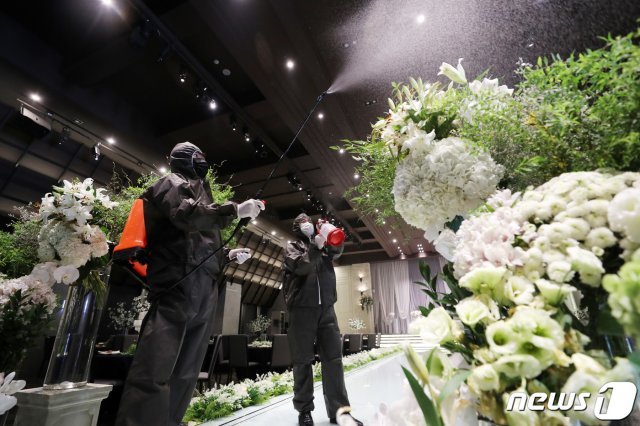 19일 오후 경기도 수원시내 한 예식장에서 직원들이 신종 코로나바이러스 감염증(코로나19) 예방을 위해 방역을 하고 있다. 최근 수도권 지역의 사회적 거리두기 2단계 격상으로 실내 50인, 실외 100인의 모임이나 행사가 전면 금지되며 결혼식, 동창회, 동호회, 야유회, 회갑연, 장례식, 돌잔치 등 사적 모임도 포함된다. 2020.8.19/뉴스1 © News1