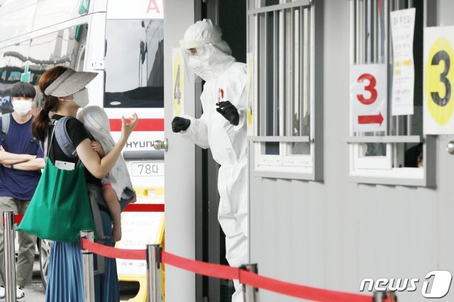 18일 사랑제일교회 소재지인 서울 성북구의 구립보건소 앞에 마련된 선별진료소에서 한 시민이 자녀와 함께 코로나19 검사를 받기 위해 의료진과 대화하고 있다. 2020.8.18/뉴스1 © News1