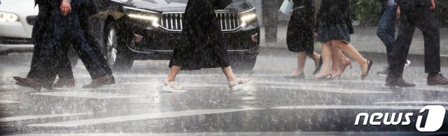 소나기가 내린 21일 오후 서울 종로구 정부서울청사 앞에서 우산을 쓴 시민들이 발걸음을 옮기고 있다. 2020.8.21/뉴스1 © News1