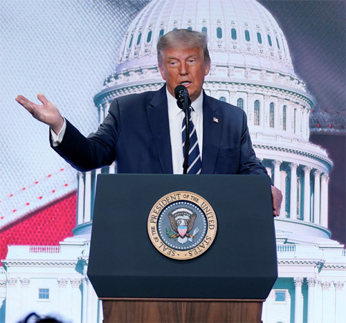 도널드 트럼프 미국 대통령이 21일 버지니아주 알링턴에서 열린 보수단체 회의에 등장해 오른손을 치켜들고 연설하고 있다. 버지니아=AP 뉴시스