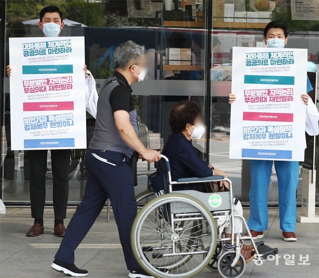 정부의 의대 정원 확대 등에 반대하는 의료계의 집단 휴진이 이어지는 가운데 24일 파업에 가세한 전임의들이 서울 종로구 서울대병원 입구에서 시위를 하고 있다. 송은석 기자 silverstone@donga.com