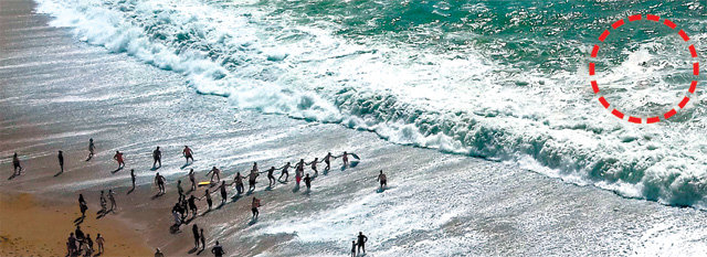 20일 영국 더들도어 해변에서 파도에 휩쓸린 남성(원 안)을 돕기 위해 해변의 사람들이 인간사슬을 만들고 있다. 사진 출처 가디언