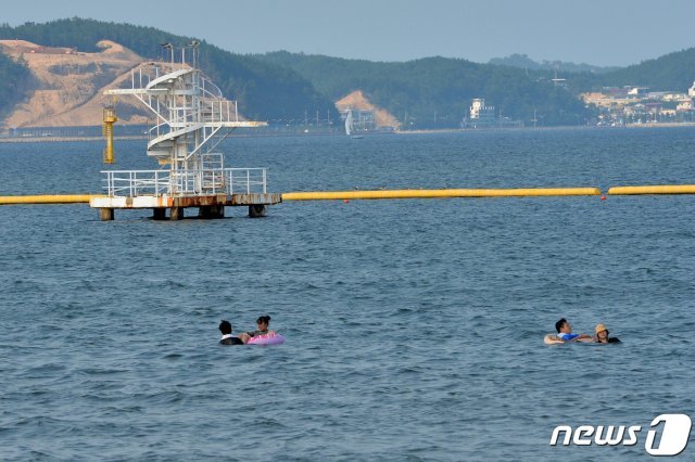 경북 포항시 전역에 폭염경보가 발령된 24일 오후 남구 송도해수욕장 다이빙대 앞에서 관광객들이 물놀이를 하고 있다. 포항지역 해수욕장은 지난 16일 일제히 폐장했지만 더위에 지친 일부 피서객들은 바다로 뛰어 더위를 식히고 있다. 2020.8.24/뉴스1 © News1