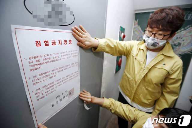 12일 광주 북구 용봉동 한 유흥시설인 감성주점에서 북구청 위생과 직원들이 행정명령서 안내문을 부착하고 있다. (광주북구 제공) 2020.5.12/뉴스1 © News1