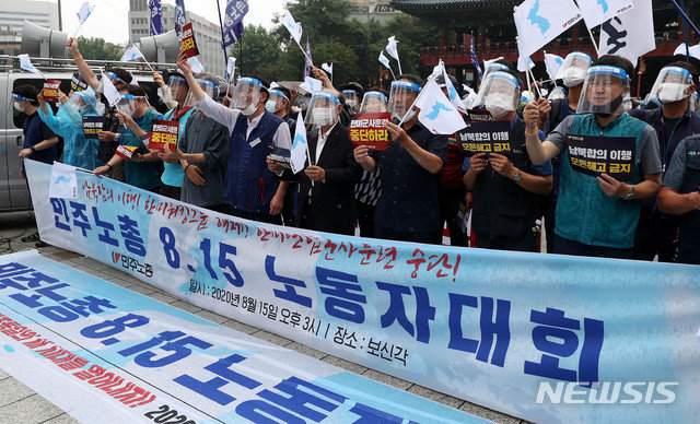 코로나19 예방을 위해 페이스 쉴드를 쓴 전국민주노동조합총연맹 노조원들이 15일 오후 서울 종로구 보신각에서 ‘ 8·15 노동자대회 성사 선포 기자회견’을 열고 한미워킹그룹해체, 한미연합군사훈련중단, 남북합의이행 등을 촉구하는 집회를 하고 있다.