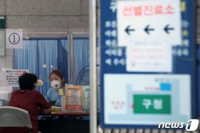 25일 오전 서울 관악구보건소에 마련된 신종 코로나바이러스 감염증(코로나19) 선별진료소를 찾은 시민이 검사를 위해 문진표를 작성하고 있다. 2020.8.25/뉴스1 © News1