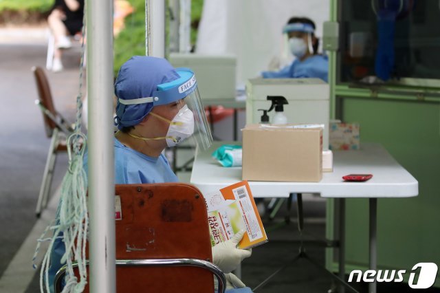 대구 달서구보건소에 마련된 신종 코로나바이러스 감염증(코로나19) 선별진료소에서 더위와 격무에 지친 의료진이 위생장갑 상자를 부채 삼아 바람을 부치고 있다. 2020.6.11 © News1