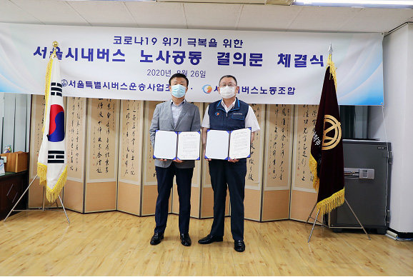 서울 시내버스 노사가 26일 코로나19 위기 극복을 위한 공동 결의문을 채택한 뒤 기념사진을 찍고 있다.