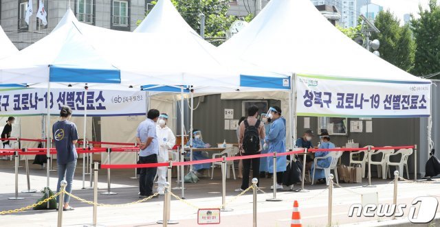 24일 오전 서울 성북구 성북구청 앞에 마련된 코로나19 선별진료소를 찾은 시민들이 검사를 받기 위해 줄지어 서 있다. © News1