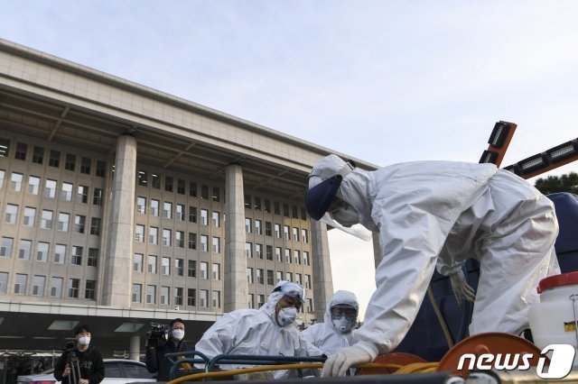 24일 오후 서울 여의도 국회 본청 인근에서 코로나19 방역 관계자들이 방역작업을 하고 있다. 국회는 신종 코로나바이러스 감염증(코로나19) 확산 사태와 관련, 24일 오후 6시부터 26일 오전 9시까지 국회 본관과 의원회관을 폐쇄하기로 했다. 국회가 감염병 때문에 폐쇄되는 것은 이번이 사상 처음이다. 2020.2.24 © News1