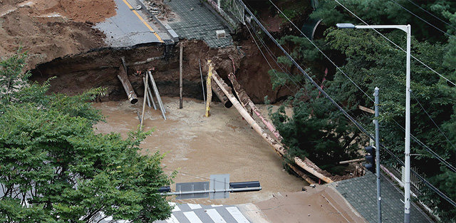 26일 경기 구리시 교문동에서 지름과 깊이가 각각 20m인 대형 싱크홀(땅꺼짐)이 발생해 관계당국이 도로를 통제하고 복구 작업을 
하고 있다. 구리시는 사고 지점 밑에 설치된 상수도관이 파열돼 땅꺼짐 현상이 나타난 것으로 추정했다. 상수도관에서 다량의 물이 
흘러 싱크홀 내에 물이 차기도 했다. 구리=뉴스1