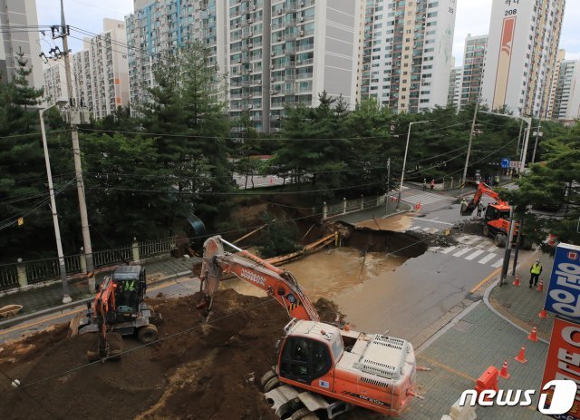 26일 오후 경기도 구리시 교문동의 한 아파트단지 앞 도로에 폭 17m, 길이 20m규모의 대형 땅꺼짐 현상(싱크홀)이 발생해 복구작업이 진행되고 있다. 현재까지 인평피해는 없는 것으로 파악됐다. 2020.8.26/뉴스1 © News1