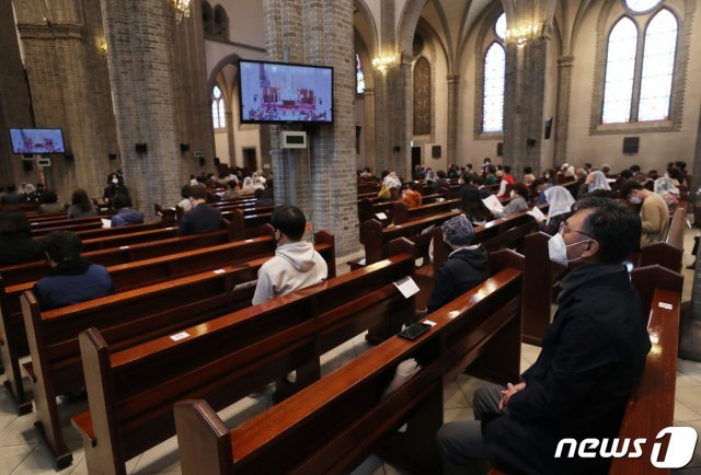 코로나19 확산 방지를 위해 각 미사 참례 인원을 250명 안팎으로 제한하고 참석자들은 긴 의자에 띄엄띄엄 붙여놓은 번호표에 맞춰 착석한 채 미사를 드리고 있는 명동성당의 모습.(자료사진) 2020.4.26 © News1