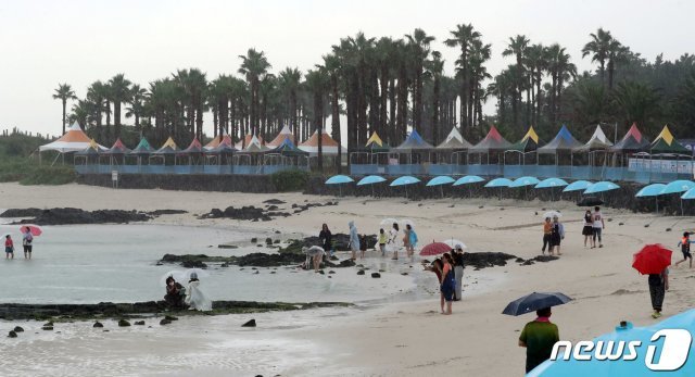 비가 내리는 7일 오후 제주시 금능해수욕장에서 관광객들이 해변을 거닐고 있다.2020.7.7 © News1